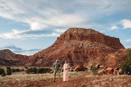 Ashley and her husband at their maternity photoshoot in a desert landscape in New Mexico