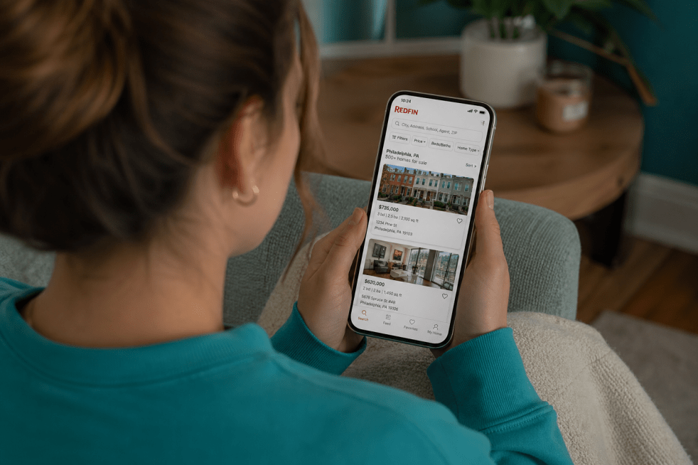 Woman sitting on couch browsing for houses on Redfin